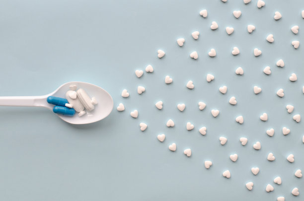 药片装在勺子里。多色药胶囊。病人正在服用治疗心脏的药物。大流行。维生素和微量元素。合成代谢的药物。兴奋剂。医药产品。图片下载