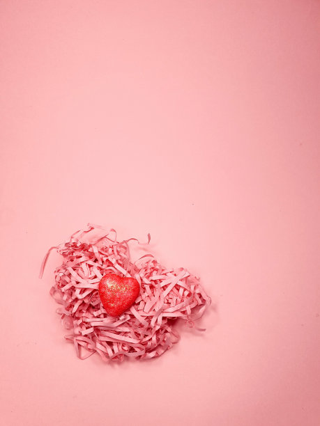 粉色纸概念心在柔和的粉红色背景，复制空间。情人节概念设计。图片下载