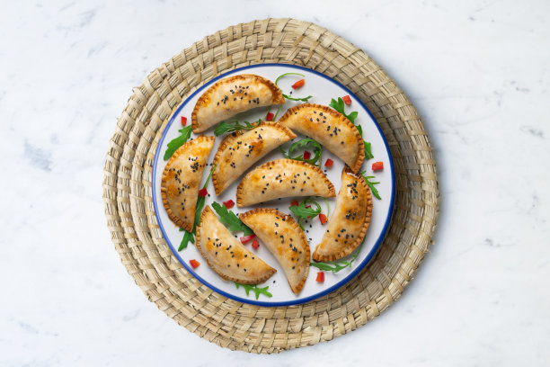 阿根廷肉馅卷饼手工制作的传统配方。用红辣椒和芝麻菜装饰的航拍照片。图片下载