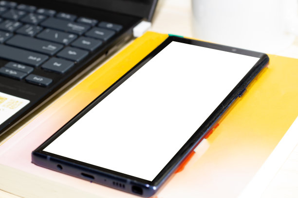 桌上有带耳机的智能手机、电脑和笔记本。图片下载