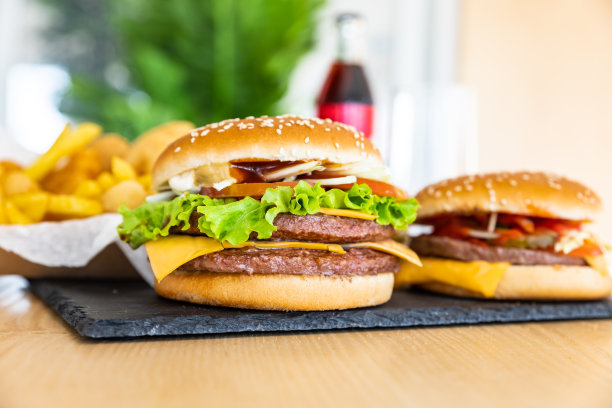 黑色石板上的经典美式汉堡和咖啡厅内部的可乐。不健康的街头食品。快餐。模糊的背景。图片下载