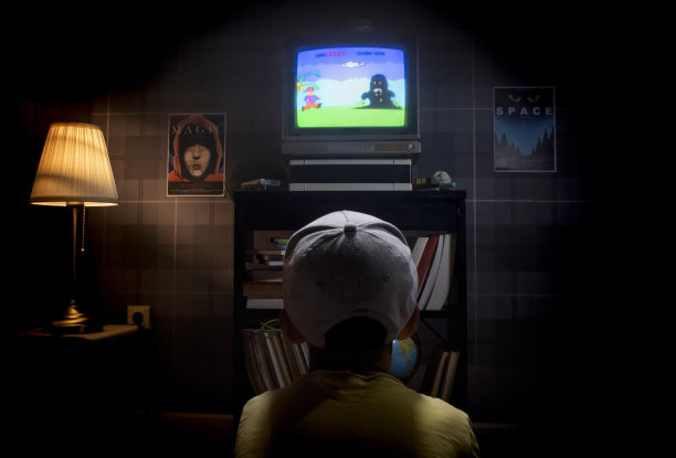 孩子坐在电视屏幕前玩游戏机游戏图片下载