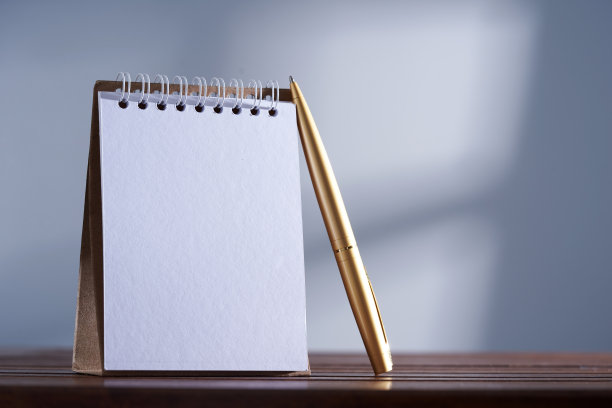 灰色背景下的三角记事本和金笔图片下载