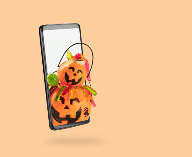 大的和小的橙色南瓜篮装满糖果从手机屏幕窥视。创意网上购物，送货和广告万圣节假期销售图片下载