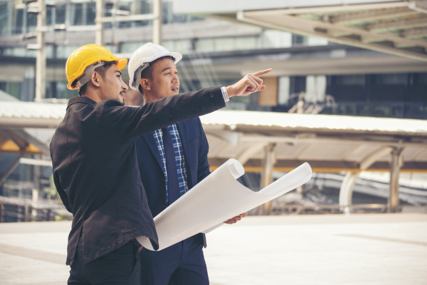 在现代城市的建筑工地上，土木工程队在一起工作时戴上工人头盔和安全帽。领班工业项目经理工程师团队。亚洲行业专业团队图片下载