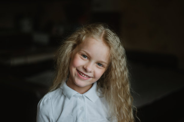 一个微笑的小女孩的特写画像，她的牙齿健康洁白图片下载