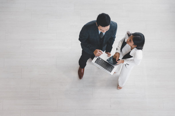 一群年轻的同事商人和女商人在正式的西装一起工作在现代办公室，俯瞰图片下载
