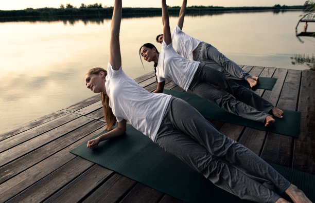 日落时分，一群人在湖边做瑜伽练习。图片下载
