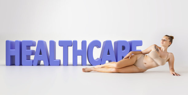 画像温柔的年轻女子躺在地板上米色内衣在3D医疗保健字母在灰色背景图片下载