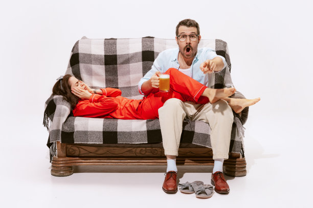 情感夫妻的肖像，男人看体育比赛和女人感到无聊。不同的兴趣图片下载