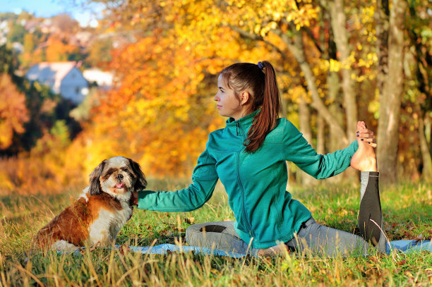 女人和她的小狗一起练习坐姿瑜伽图片下载