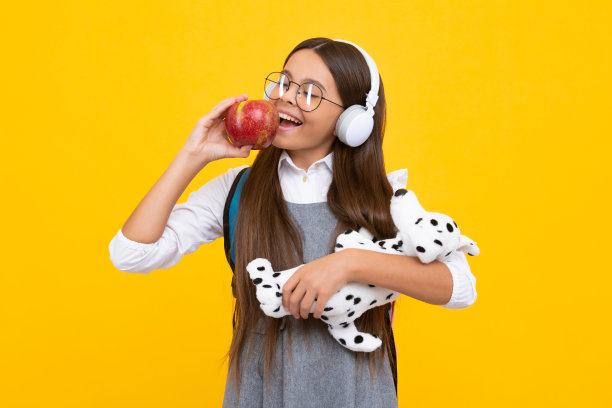 学校十几岁的孩子女孩与书苹果和背包持有玩具。有趣的研究。教育和儿童观念。图片下载