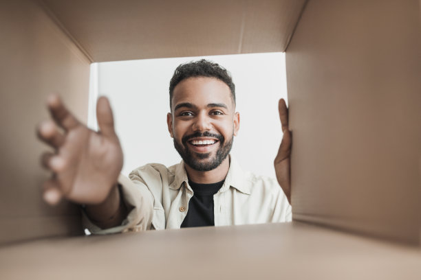 惊奇兴奋的男人打开包裹。交付的概念图片下载