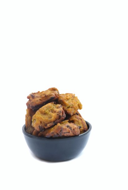 在垂直方向上孤立于白色背景的黑色碗里的红扁豆瓦达图片下载