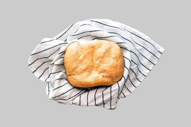 新鲜出炉的白面包放在毛巾上，背景是孤立的图片下载