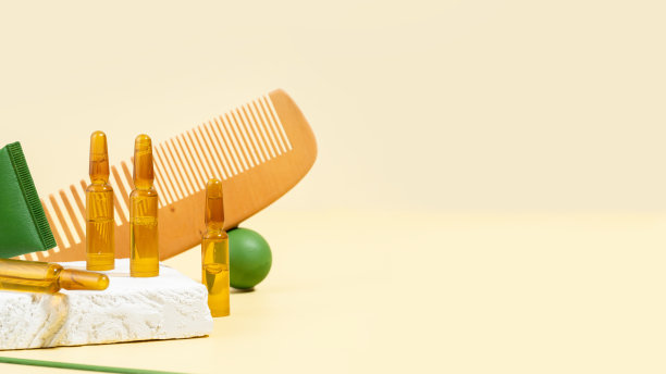 美容安瓿，含有用于头发生长和修复的血清。米色背景下的梳子和绿色道具。概念美容美发，自我护理，水疗和健康。现代创意照片。副本的空间。图片下载