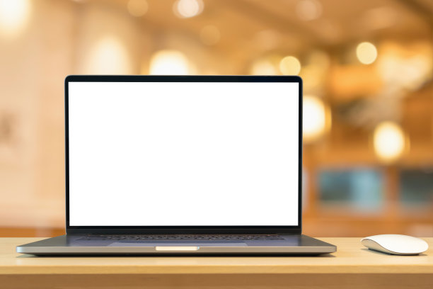 笔记本电脑与空白屏幕上的木桌与咖啡馆咖啡店模糊的背景图片下载