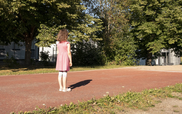 一个白人女孩站在起跑线上，准备跑跳远。图片下载