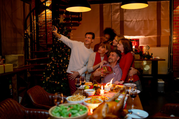 白种人家庭在圣诞节期间一起享受和自拍，晚上他们在家里庆祝。图片下载