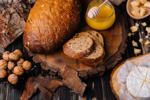 面包配蜂蜜，核桃和奶酪放在木桩上图片下载