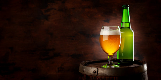 啤酒杯和啤酒瓶放在木桶上图片下载