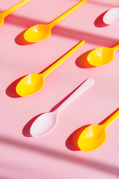 粉色背景的一次性塑料冰淇淋勺。图片下载