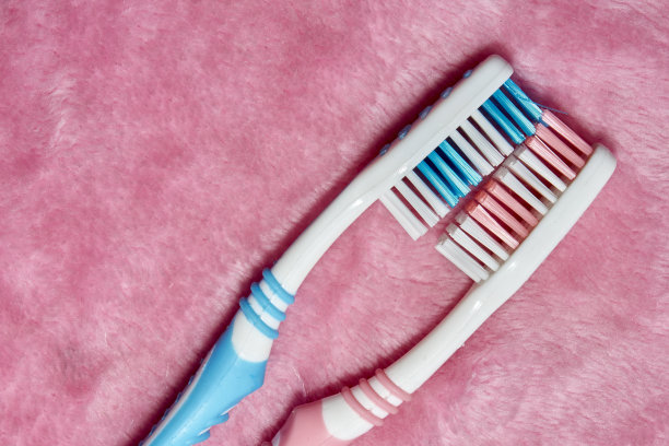 两把牙刷放在一条粉色蓬松的毛巾上图片下载