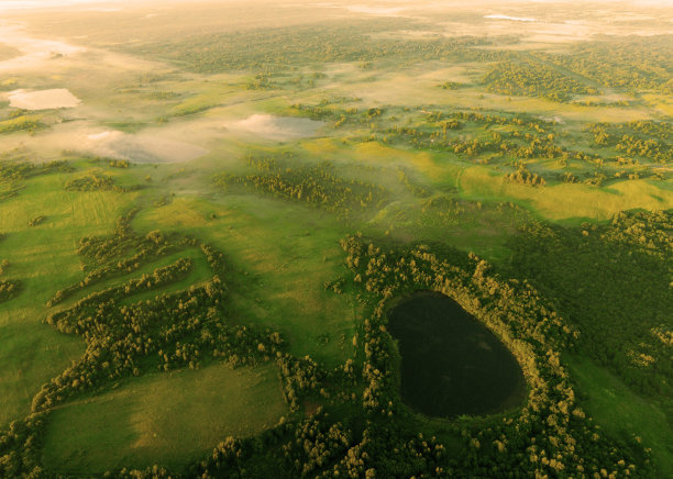 湖在晨雾中日出。田园风光中的池塘。黎明时分的湖面上有雾，鸟瞰图。图片下载