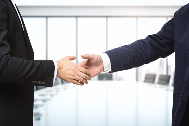 在明亮的会议室背景下，两位商人握手，合作理念，近距离接触图片下载