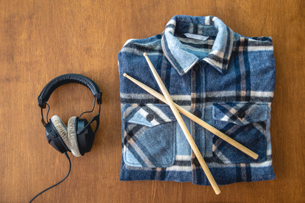 耳机和一件折叠的格子衬衫，背景是木制的。图片下载