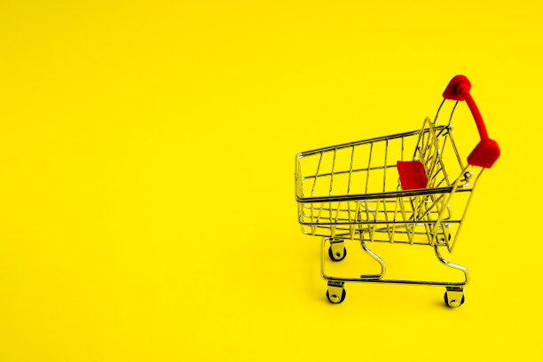 黄色背景的购物车。购买和销售的主题。图片下载