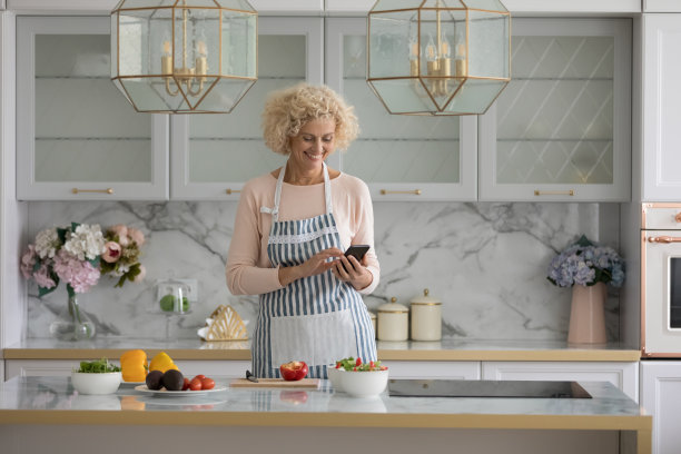 快乐的金发美女在厨房做沙拉图片下载