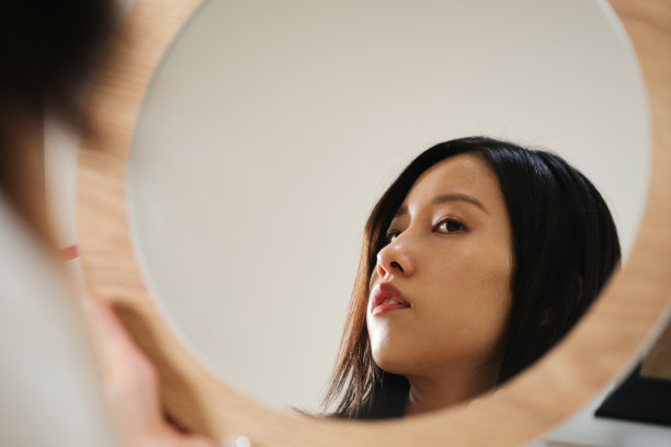 年轻女子看着镜子图片下载