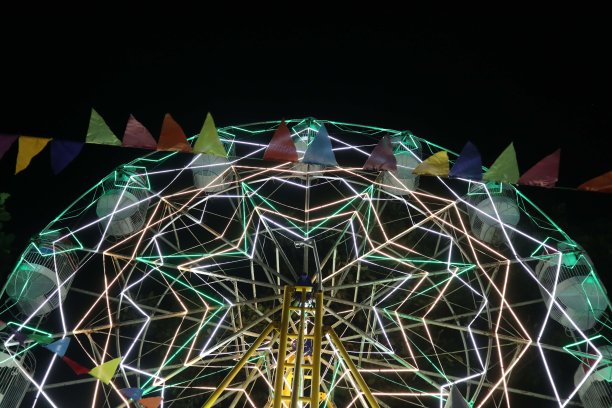 摩天轮在夜间节日的慢动作照片。肆意挥霍的人图片下载