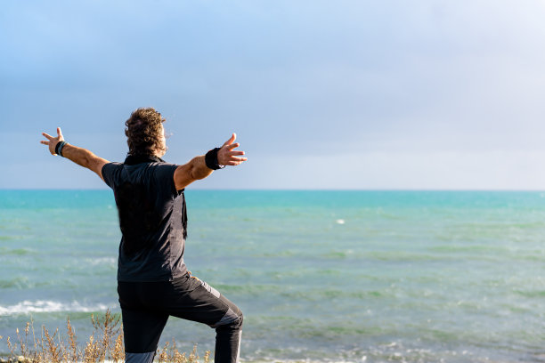 50多岁的中年男人，面朝大海，张开双臂，体味自然，倾听自然，寻求平静与幸福图片下载