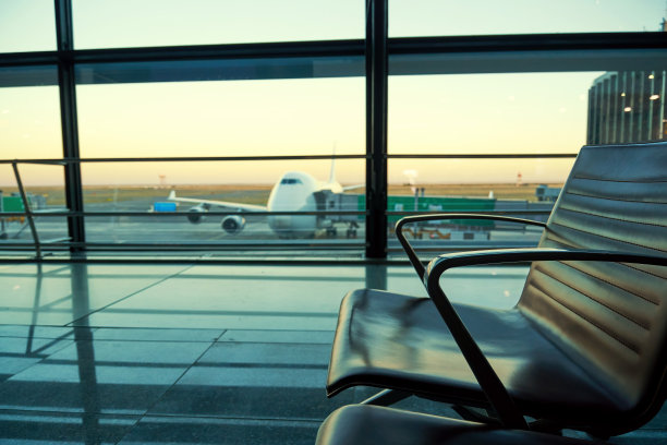 机场大厅里的椅子和黄昏中的飞机剪影图片下载