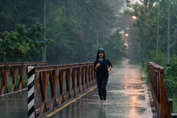 亚洲女士在雨中奔跑图片下载