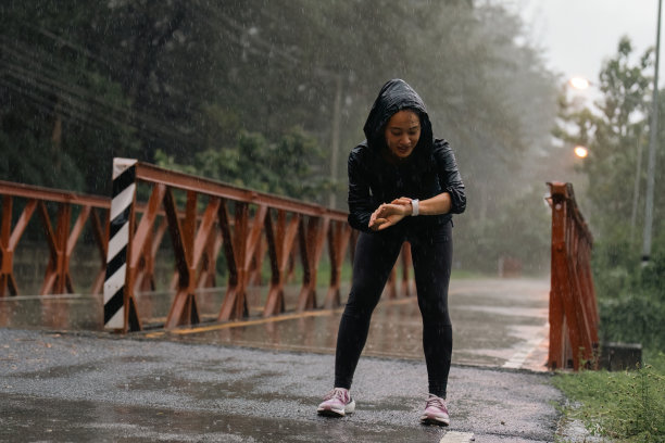 亚洲女士在雨中奔跑，她很累图片下载