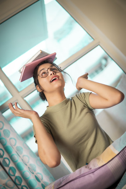 快乐的青少年学生，手里拿着书，在家里玩得很开心。图片下载