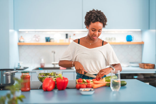 年轻的西班牙裔女性在厨房做饭图片下载