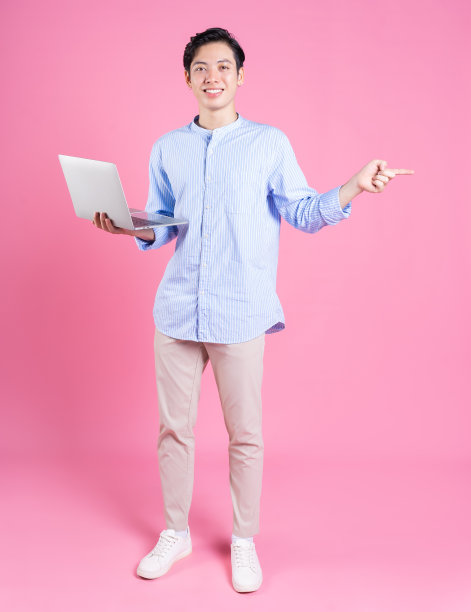 年轻的亚洲男子在背景中用笔记本电脑图片下载