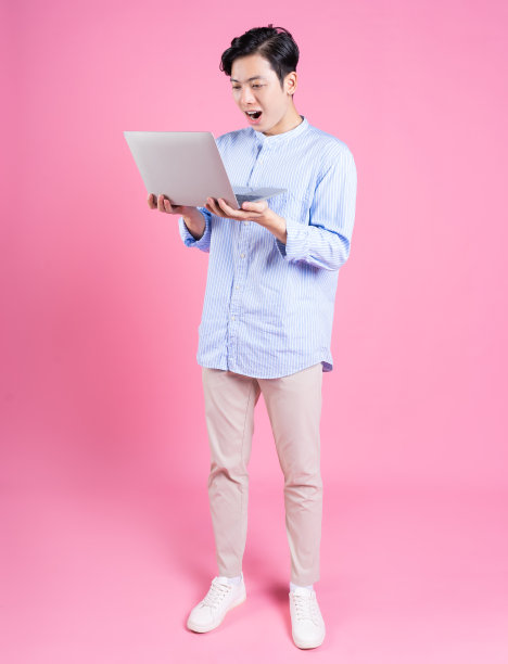年轻的亚洲男子在背景中用笔记本电脑图片下载