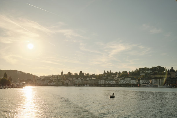 阳光普照的湖，日落时有船图片下载