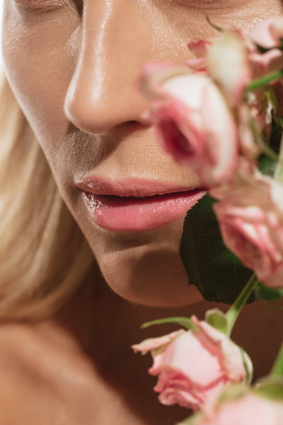 温柔的嘴唇。特写美丽的年轻女子花孤立在白色背景。化妆品，自然美和美学的美容观念。图片下载