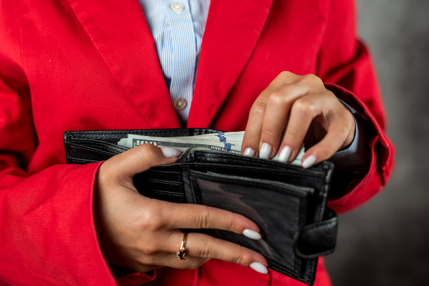 女孩在购物前手里拿着一个钱包，数着里面的美元。图片下载