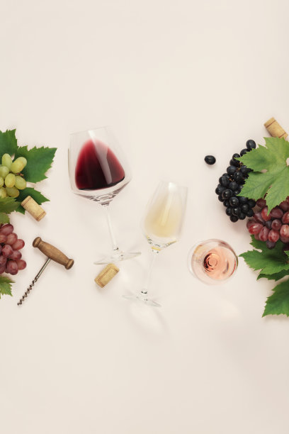 平装红葡萄酒、玫瑰和白葡萄酒，装在粉色背景的玻璃杯里图片下载