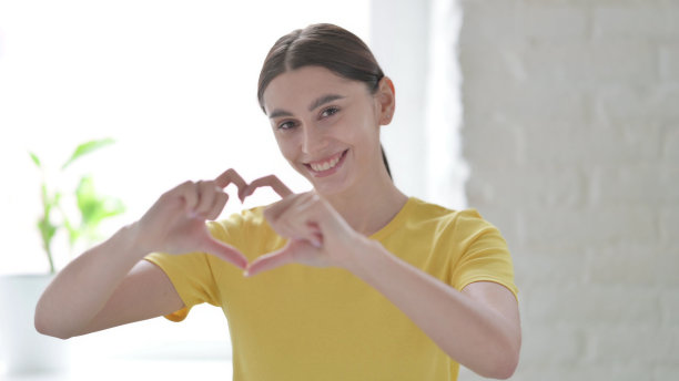 用手展示心脏形状的妇女肖像图片下载