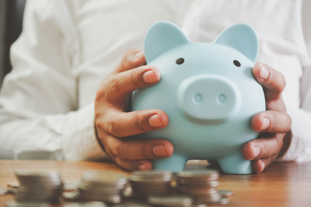 节能省钱的理念。储蓄或投资的想法。手把钱硬币放进小猪存钱财富存钱硬币在表概念金融。图片下载