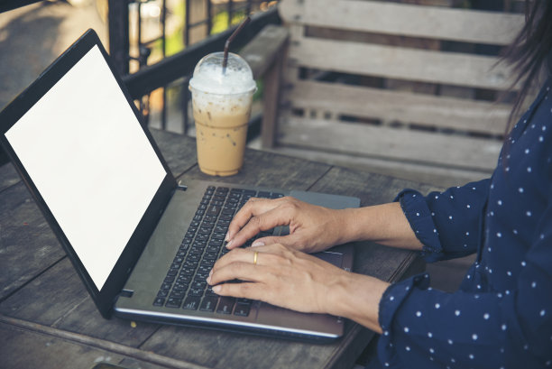 亚洲女性自由职业者使用笔记本电脑在家里的办公桌。妇女阅读财务图表计划分析市场数据。亚洲女性工作的办公室，公司和商业的东西，咖啡杯图片下载