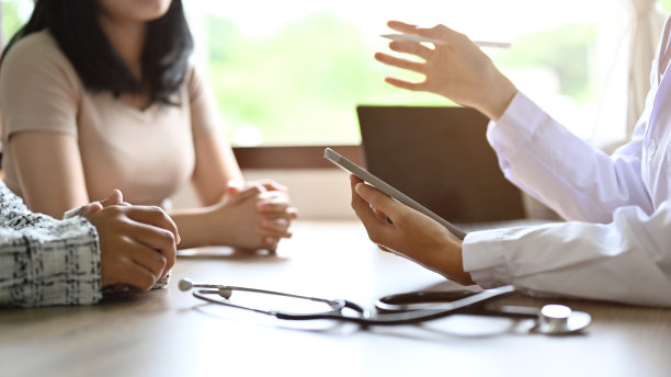 一位女医生在办公室会见她的病人，询问症状。裁剪图片下载